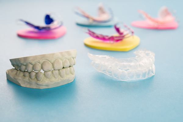 Photo of five retainers and a model of teeth.