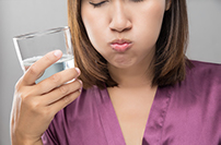 close up of woman using a salt water rinse to manage comfort
